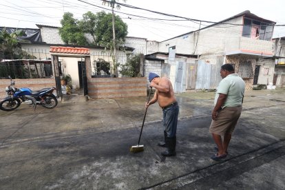 Julio César Indacohcea se levantó temprano para limpiar y recoger los vidrios que quedaron el portal de su casa y en la peatonal que une la manzana 7 y 9, en Guayaquil.