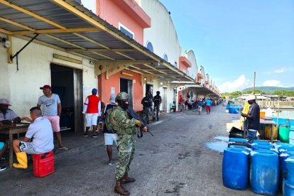 Mientras los militares rondan en la zona, unos trabajadores se distraen jugando cartas.