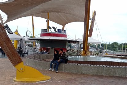 Los locales en la plazoleta son usados por estudiantes para conversar.