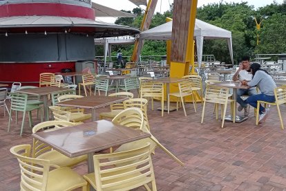 Una pareja de estudiantes conversa en medio de la soledad que reina en la parte donde antes operaban unos locales de comida rápida y varios.