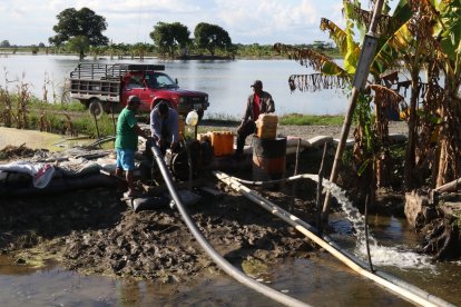 Con motobombas, agricultores extraen el agua que inundó sus cultivos.