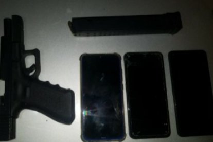 E poder de los detenido se halló esta arma de fuego, municiones y tres celulares.