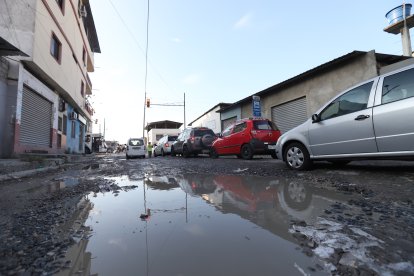 El agua de las lluvias se estanca en los grandes baches que se han formado en la calle Luis Naranjo Noboa.