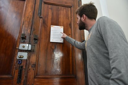 Un turista observa un escrito en la puerta  del hotel con recomendaciones de seguridad.