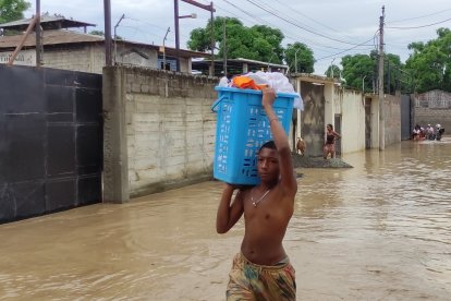 Un hombre intenta salvar sus pertenencias ante las inundaciones en Esmeraldas.
