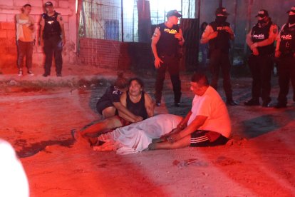 Las familias de las víctimas lloran a sus seres queridos  ante las miradas curiosas.