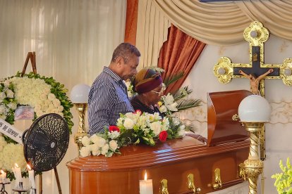 Familiares y amigos de Rider Sánchez rezan junto a su féretro.