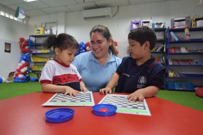 La 'Miss' Laura Mosquera enseñando ajedrez a sus pequeños estudiantes.