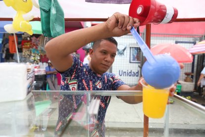 José Araujo recibe la ayuda de una minibocina para la venta de jugo de naranja.