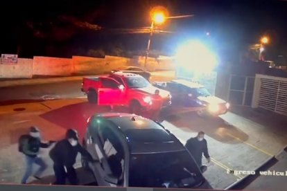 Los delincuentes se bajan y se acercan al auto del residente.