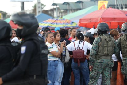 Familiares de reos se agolpan en los exteriores de  la ‘Peni’, la cual es resguardada por policías y militares, para buscar información de sus parientes.