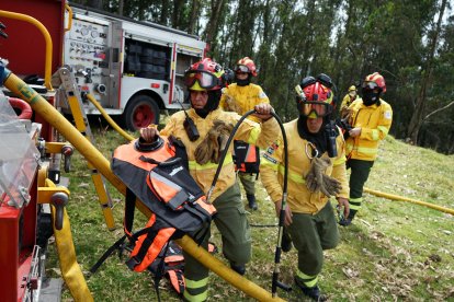 Los bomberos utilizan mochilas con agua para controlar las llamas.