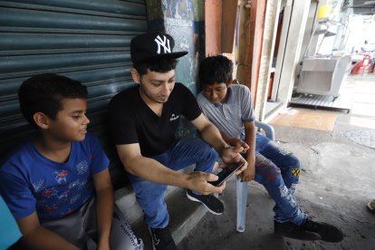 Jugando después de trabajar, Joel Macías quemó el tiempo en el celular a la espera de los resultados.
