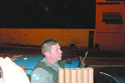 Un policía brasileño llevando los tremendo tubos de pólvora usaban los hinchas de Fluminense