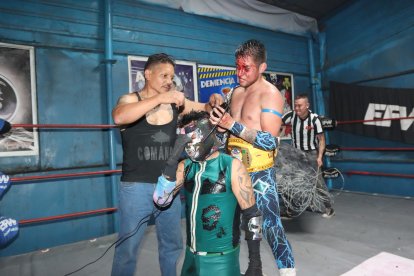 Entre luchadores se ayudan para estar listos antes de una pelea.