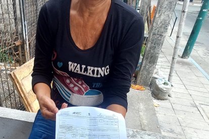 Una pariente muestra los documentos para retirar a su ser querido.