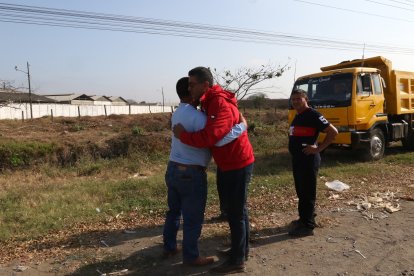 William Aguilar (rojo), tío del fallecido, recibe el consuelo de sus compañeros de labores.