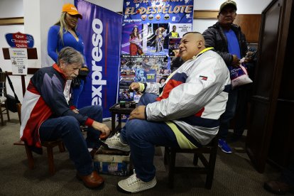 Manuel Paredes (i) cumpliendo el rito en la tradicional zapatería.