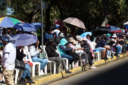 Los espectadores se cubrieron como podrían del sofocante sol.