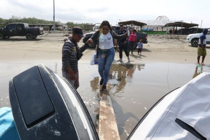 Ante la falta de un muelle, los lancheros usan tablas para embarcar a los comuneros.