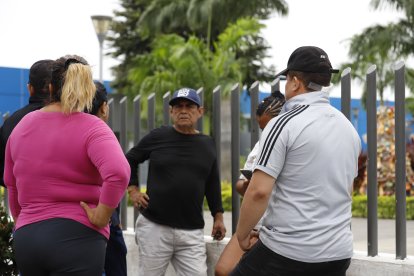 El padre de los niños (camiseta blanca) tiene una herida en la parte posterior del cuello. Llegó a la morgue acompañado de sus familiares.