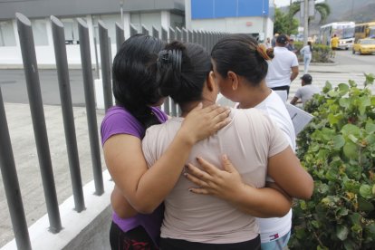 Los familiares de los hermanos Martínez Lino se abrazan para brindarse consuelo.