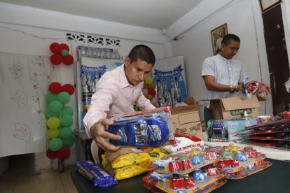 Gipson (izquierda) alista los juguetes que entregará en Navidad.