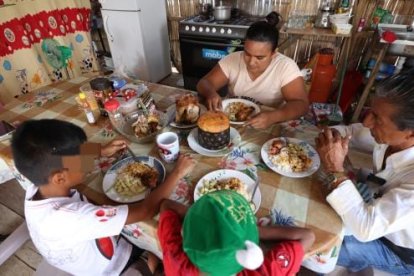 Una oración antes de cenar, la familia unida en la mesa navideña.