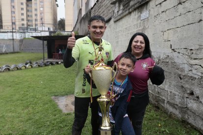 Cali, como conocen al golero, junto a su esposa Sandra Erazo y el trofeo de campeón.