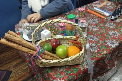 Regala una canasta con manzanas rojas, verdes y ramas de canela.