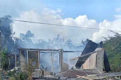 De la casa todavía sale humo del incendio.