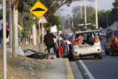 Vendedora informal de ropa utiliza parte de la calzada para comercializar sus productos.