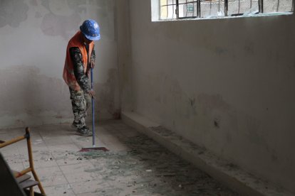 trabajadores limpian los vidrios que reventaron tras la explosión en la Martha Bucaram