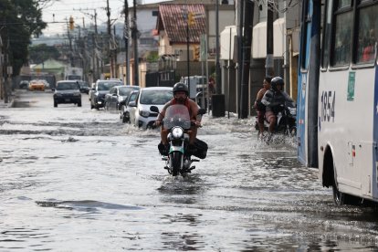 Vehíulos livianos y pesados con dificultad para transitar por calles inundadas de Urdesa.