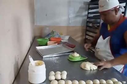 Ronald Mite preparando los panes para su venta diaria.