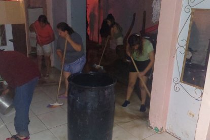 Vecinos ayudaron a las dos familias a limpiar su vivienda. Sacaron agua y lodo.