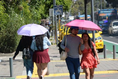 Los capitalinos se cubren del sol.