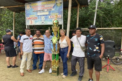 JoséMoreira (camiseta blanca) y dirigentes barriales de Guayaquil junto al megatrofeo del campeón.