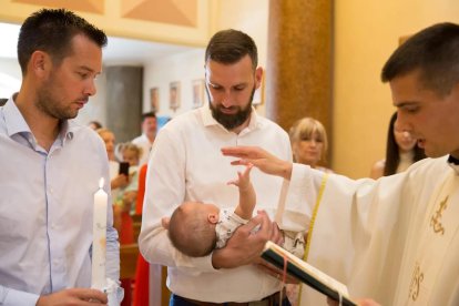 Klarica administra el santo sacramento del bautizo a un pequeño.