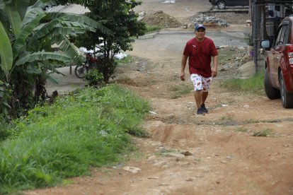 Edison Murgueza camina cuidadosamente para no caerse en esa calle sin asfalto.