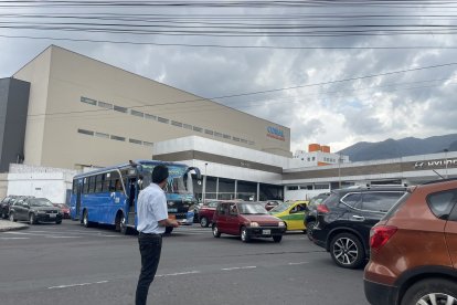 El ayudante de un bus mientras trata de hacer que el tráfico fluya.