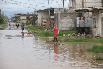 Una señora espera que alguna motocicleta o camioneta le ayude a salir del sector.