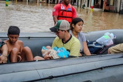 En botes se trasladaron a las familias y unos padres con sus nenes en brazos.