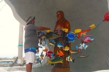 El pescador arregla la imagen y también participa de la procesión náutica en honor a Cristo Pescador en Santa Rosa, a finales de julio.