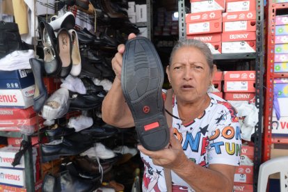 Norma Chang muestra los emblemáticos zapatos que vende.