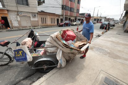En pleno 'solazo', Édison Macías labora en su triciclo con desechos.