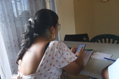 Angélica obsrva con tristeza la fotos de sus familiares que guarda en su celular.