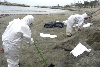 Con material adherente procuraban retirar el crudo de la playa.