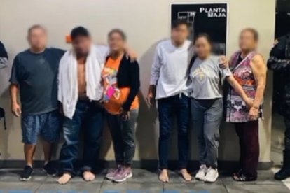 Los dos raptados, sin zapatos, junto a sus familiares.