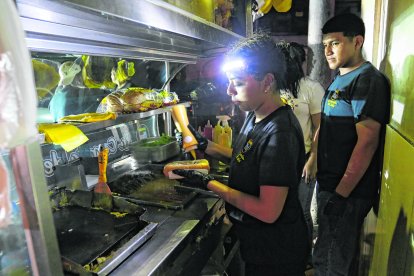 Una cocinera utiliza una linterna en la frente para preparar los alimentos.